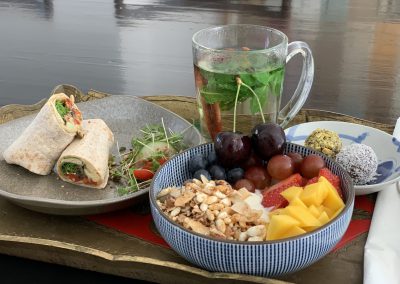Vegan ontbijt: wrap gegrilde groenten en hummus, granola bowl met vers fruit, choco-dadelballen