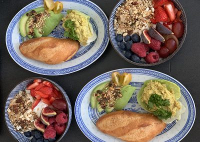 Vegan ontbijt: pistolet vegan kip-kerrie en avocado, granola bowl met vers fruit en kokos-soja yoghurt