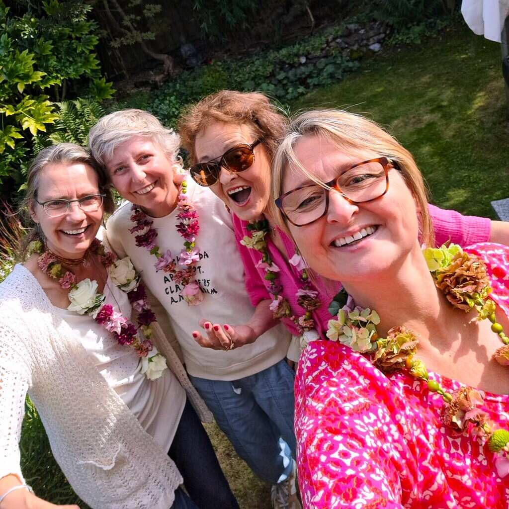 Shakti Bloemenmala Tonny Bol Shakti Flower Meeting deelnemers bloemenslingers omgehangen lachend groepsfoto tuin Berg en Dal regio Nijmegen