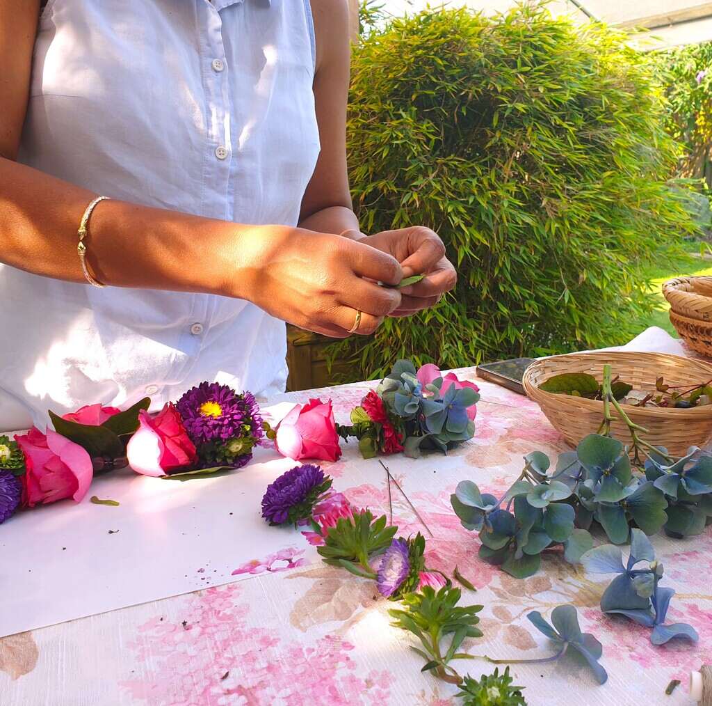 Shakti Bloemenmala Tonny Bol workshop cursist geconcentreerd bezig vouwen hortensiablad bloemenworkshop bloemenslingers maken tuin tafel