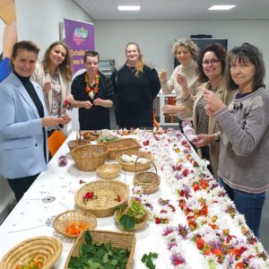 Shakti Bloemenmala Tonny Bol workshop lange bloemenslingers maken Korak Herstelacademie Heerde tafel vol manden verse bloemen samen poseren