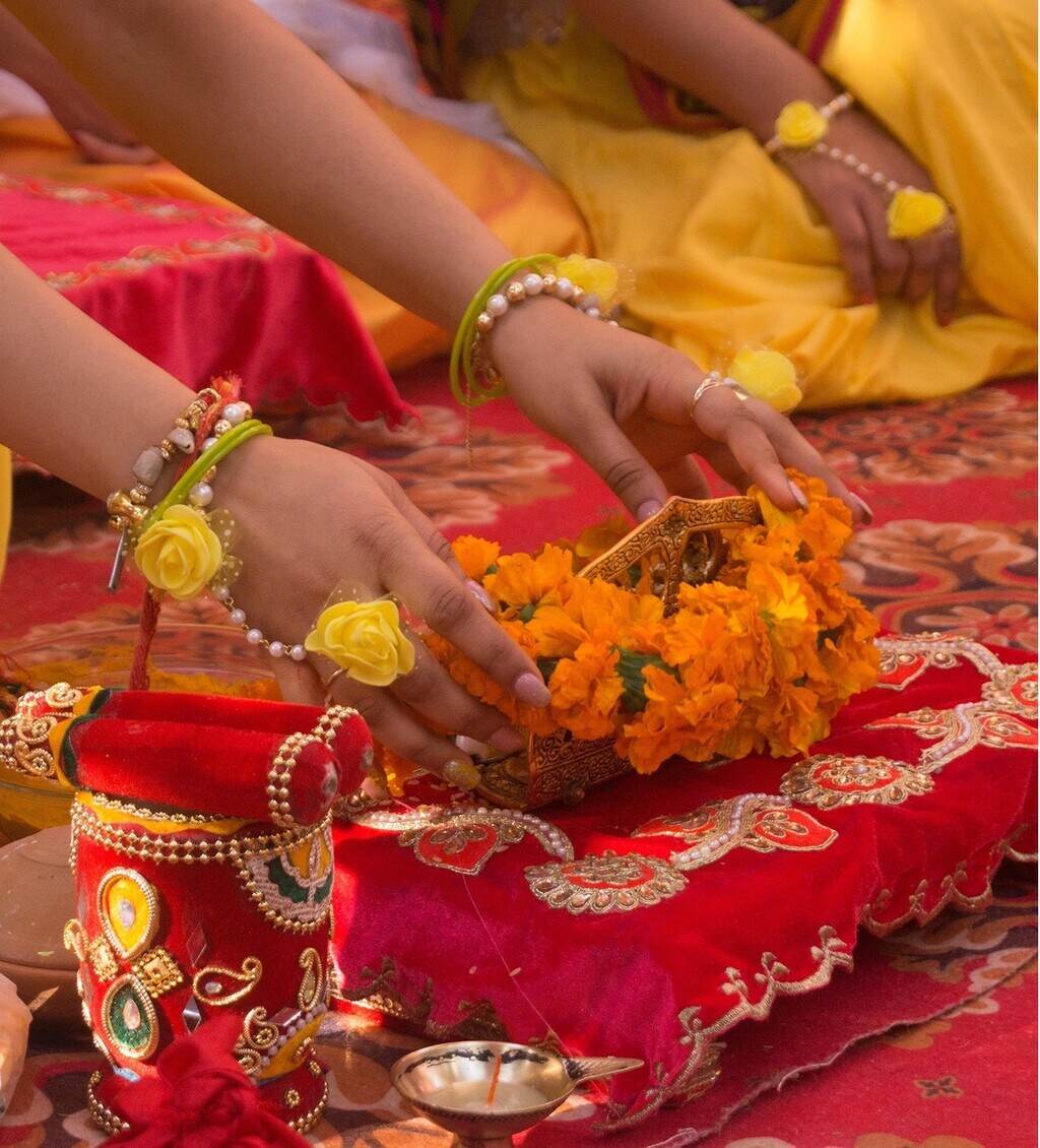 Shakti Bloemenmala Tonny Bol Indiase culture rituelen bloemen offerande sierlijk rood kussen religieuze attributen gele kleding Rust in je hoofd en ruimte in je hart