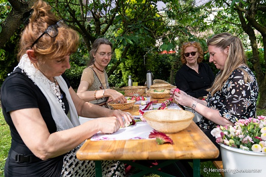 Shakti Bloemenmala Tonny Bol groepsfoto workshop, 4 mensen aan tafel in boomgaard
