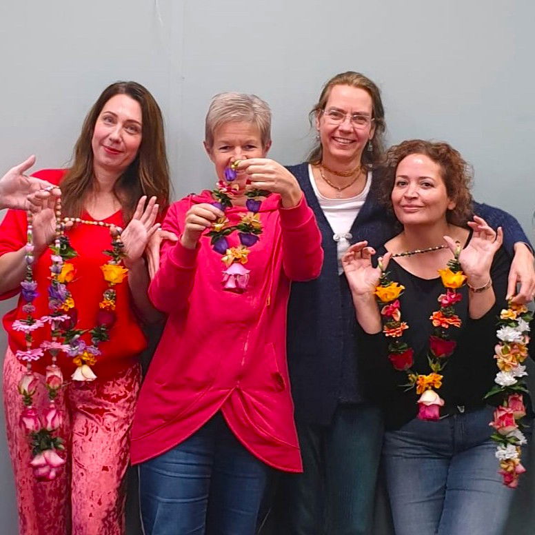 Shakti Bloemenmala Tonny Bol groepsfoto vrolijke deelneemster workshop bloemenmala's maken kleurrijke gevarieerde bloemenslingers verse bloemen
