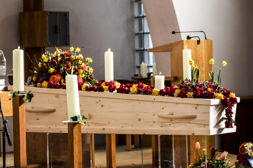 Shakti Bloemenmala Tonny Bol uitvaartkist bloemenslinger omlijsting bovenop gedrapeerd tros afhangend warm aanzicht