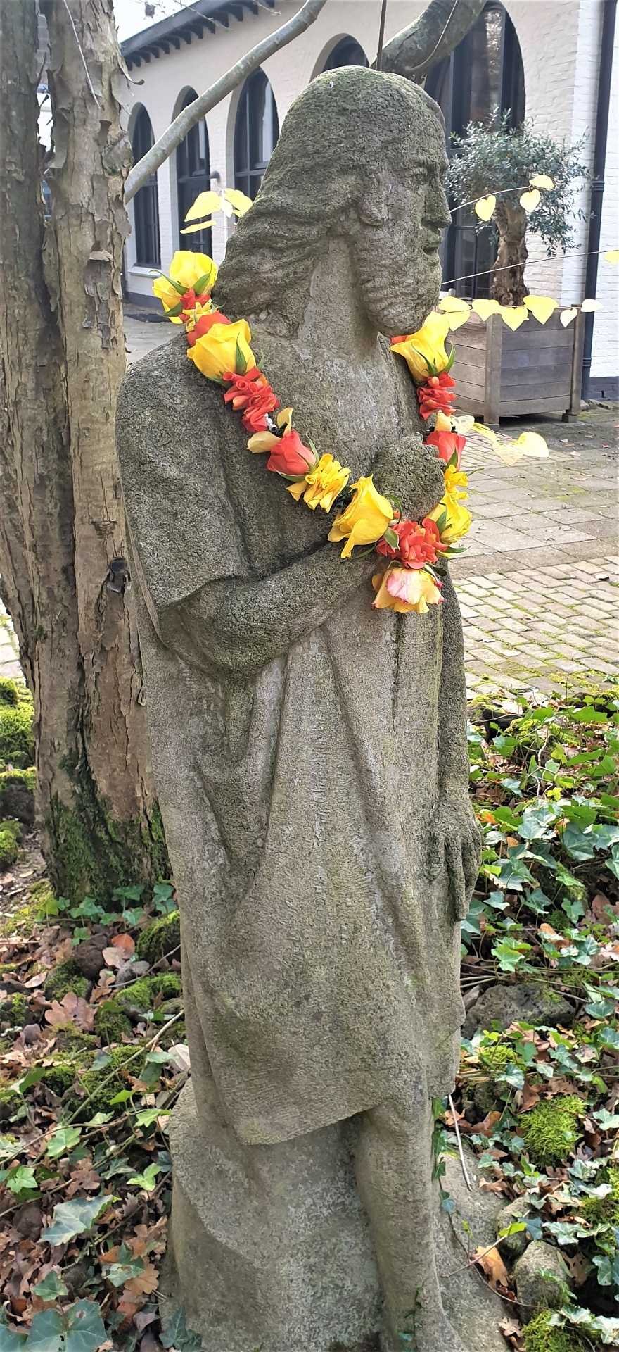 Shakti bloemenmala's Tonny Bol Jezusfiguur met gele middel grote mala bij ingang Gedenkpark Heilig Landstichting