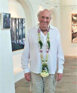 Shakti Bloemenmala, Tonny Bol, Leo poseert met bloemenslinger om bij expositie Kerkje van Persingen