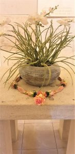 Shakti bloemenmala's Tonny Bol Mala om pot bij Crypgraven in het rijksmonument de Calvarieberg in Gedenkpark Heilig Landstichting