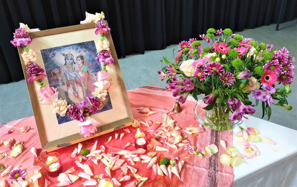 Shakti bloemenmala's Tonny Bol mala om schilderij Radharani en Krishna op altaar en bos bloemen in vaas