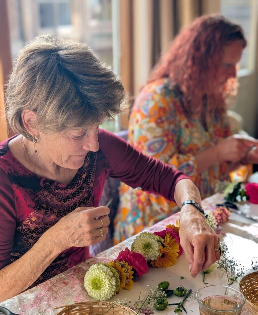 Shakti Bloemenmala Tonny Bol Shakti Flower Experience workshop kerstsfeer verse bloemen aanrijgen naald draad verse kleurrijke bloemen meditatief