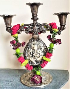 Shakti bloemenmala's Tonny Bol minimala om kaarsenkandelaar met Ganesha afdruk erin